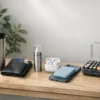 Entryway table with organized travel wallet, travel mug, refillable hand sanitizer, wireless earbuds, power bank, and battery organizer.